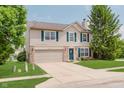 Inviting two-story home with blue shutters, a well-maintained lawn, and a brick-accented facade at 6703 Wimbledon Dr, Zionsville, IN 46077