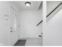 Bright foyer features white walls, a decorative front door, and access to the staircase at 6703 Wimbledon Dr, Zionsville, IN 46077