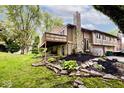 Home featuring a spacious deck overlooking a well-manicured lawn and mature trees at 8024 Sunfield Ct # 5-B, Indianapolis, IN 46214