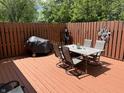 Spacious deck with a dining set, grill, and wooden fence with decorative metal artwork at 8206 Bull Run Ct, Indianapolis, IN 46227