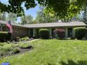 Beautiful single-story brick home with large front yard, manicured lawn, and colorful flower beds at 8206 Bull Run Ct, Indianapolis, IN 46227