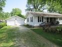 Home exterior with a detached two-car garage and a charming front porch seating area, offering a welcoming curb appeal at 852 Walnut St, Greenfield, IN 46140