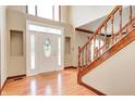 Bright foyer featuring hardwood floors, staircase with wooden banister, and ornate front door at 9158 Oak Knoll Ln, Fishers, IN 46037