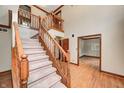 Entryway featuring carpeted stairs, wood trim, and views to an adjacent room with wood flooring at 9158 Oak Knoll Ln, Fishers, IN 46037