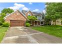 Traditional brick home with an attached two-car garage and a spacious driveway at 974 Arrowwood Dr, Carmel, IN 46033