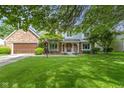 Beautifully landscaped front yard with a classic brick and siding home at 974 Arrowwood Dr, Carmel, IN 46033