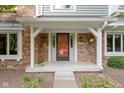 Inviting front porch with brick accents and a decorative front door at 974 Arrowwood Dr, Carmel, IN 46033