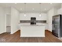 Bright kitchen features an island, stainless steel appliances, white cabinets and sleek countertops at 104 Maxim Ct, Cumberland, IN 46229