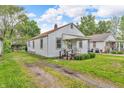 Quaint single-story home with a welcoming porch and a driveway, surrounded by green grass at 1124 S Lockburn St, Indianapolis, IN 46241