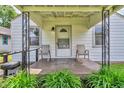 Inviting front porch with seating, lush greenery, and a view of the charming home's entrance at 1124 S Lockburn St, Indianapolis, IN 46241