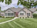 Beautifully landscaped home with stone accents, trimmed lawn, and an inviting walkway at 1130 Deerbrook Trl, Greenwood, IN 46142