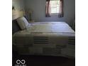 Comfortable bedroom features natural light with a decorative bed frame, and window at 1212 River Heights Dr, Indianapolis, IN 46240