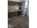 Functional kitchen featuring wooden cabinets, laminate floors, and essential appliances for meal preparation at 1212 River Heights Dr, Indianapolis, IN 46240