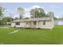 Charming single-story home featuring a well-maintained lawn and inviting front porch with an American flag at 125 S Alfonte St, Ingalls, IN 46048