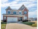 Inviting two-story home with brick and gray siding, showcasing a spacious driveway and manicured front lawn at 1381 Avocet Dr, Greenwood, IN 46143