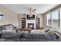 Cozy living room features a fireplace, ceiling fan, plush gray sofa, and TV for relaxed entertainment at 1381 Avocet Dr, Greenwood, IN 46143