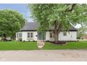 Charming home with lush lawn and mature trees, creating a serene and inviting outdoor space at 1502 Burdsal Pkwy, Indianapolis, IN 46208