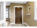 Inviting entryway showcasing a dark wood door, tiled floors, and neutral walls with decorative accents at 1526 Carrollton Ave, Indianapolis, IN 46202