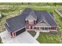 A high angle view of a home with a dark roof, lush lawn, and long driveway at 1595 N Blue Rd, Greenfield, IN 46140