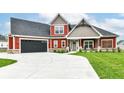 Inviting two-story home showcasing a well-manicured lawn and dark garage doors at 1595 N Blue Rd, Greenfield, IN 46140