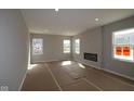 Bright living room featuring a fireplace and large windows at 16835 Cheddar Dr, Noblesville, IN 46060
