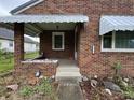 Charming front porch with brick surround and stairs leading up to front door at 1739 Crystal St, Anderson, IN 46012