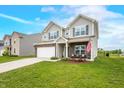 Charming two-story home with a manicured lawn, attached two-car garage, and inviting front porch at 1893 Glenmoor Ct, Columbus, IN 47201