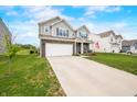 Charming two-story home with a manicured lawn, attached two-car garage, and inviting front porch at 1893 Glenmoor Ct, Columbus, IN 47201