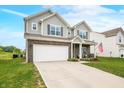 Charming two-story home with a manicured lawn, attached two-car garage, and inviting front porch at 1893 Glenmoor Ct, Columbus, IN 47201
