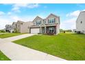 Attractive home boasting a manicured lawn, two-car garage, gray siding, and a welcoming front porch area at 1893 Glenmoor Ct, Columbus, IN 47201