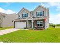 Beautiful home with gray siding, brick accents, a green lawn, and a driveway leading to an attached garage at 1893 Glenmoor Ct, Columbus, IN 47201