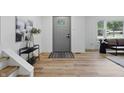 Bright entryway with light wood floors, a decorative rug, and a modern gray door at 2009 Friendship Dr, Indianapolis, IN 46217