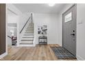 Bright entryway featuring a staircase, modern decor, light wood floors, and a stylish gray door at 2009 Friendship Dr, Indianapolis, IN 46217