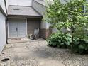 Front entryway featuring a gray double door with a rocking chair and landscaped surroundings at 35 Osage Ct, Columbus, IN 47201