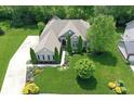 Beautiful aerial shot of brick home with manicured lawn and lush landscaping surrounding the property at 3815 Harrison Crossing Ln, Greenwood, IN 46142