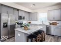 A bright kitchen with stainless steel appliances and gray cabinets at 3899 Sterling Dr, Whitestown, IN 46075