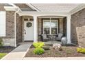 Inviting front porch with stylish seating and stone accents, perfect for relaxing outdoors at 4659 W Otway Ln, New Palestine, IN 46163