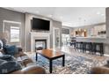 Open-concept living room with a cozy fireplace, a plush leather sofa, and views into the dining area at 4659 W Otway Ln, New Palestine, IN 46163