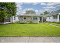 Beautifully maintained front lawn and exterior of a cozy home on a sunny day, showcasing its curb appeal at 5225 E St Clair St, Indianapolis, IN 46219