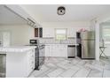 Bright, remodeled kitchen with white cabinets, stainless steel appliances, and stylish tile flooring at 5236 Honey Comb Ln, Indianapolis, IN 46221
