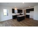 Modern eat-in kitchen features a center island, stainless steel appliances, and wood-look flooring at 6223 Medina Spirit Dr, Indianapolis, IN 46237