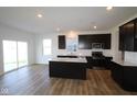Modern eat-in kitchen features stainless steel appliances, an island, and sliding door access to the yard at 6223 Medina Spirit Dr, Indianapolis, IN 46237