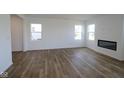Open concept living room features wood-look flooring, recessed lighting, and a fireplace at 6223 Medina Spirit Dr, Indianapolis, IN 46237