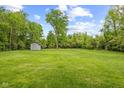 Expansive green backyard with a storage shed in a serene setting at 6230 E 56Th St, Indianapolis, IN 46226