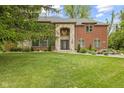 Well-maintained front yard with lush green lawn, beautiful landscaping, and grand home at 6230 E 56Th St, Indianapolis, IN 46226
