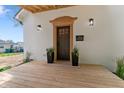 Covered front porch featuring a wooden deck, stylish lighting, and black front door at 650 Overstreet St, Franklin, IN 46131
