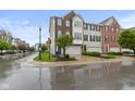 Three-story townhome featuring attached garages, brick and siding exteriors, and professionally landscaped grounds at 6916 Havenmoor Pl, Indianapolis, IN 46250