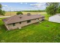 Home's rear exterior and yard showing siding, roofing, and a fire pit at 6925 W State Road 128, Frankton, IN 46044