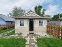 The home's quaint front entrance with a dark door and white trim and shutters creates a welcoming ambiance at 704 E Perry St, Indianapolis, IN 46227
