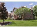 Beautiful brick home with a well-maintained lawn and mature trees at 7430 Franklin Parke Woods, Indianapolis, IN 46259